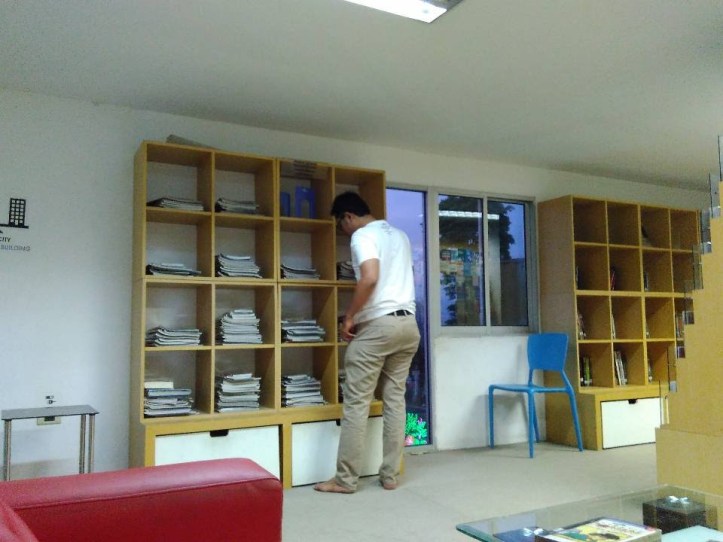 Buku dan majalah diletakkan di rak-rak kayu. Photo credit: Koleksi Pribadi